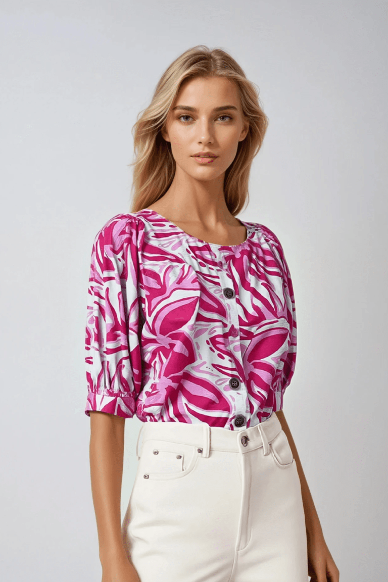 Blusa de chalis blanca con estampado rosa, cuello redondo y mangas abullonadas.