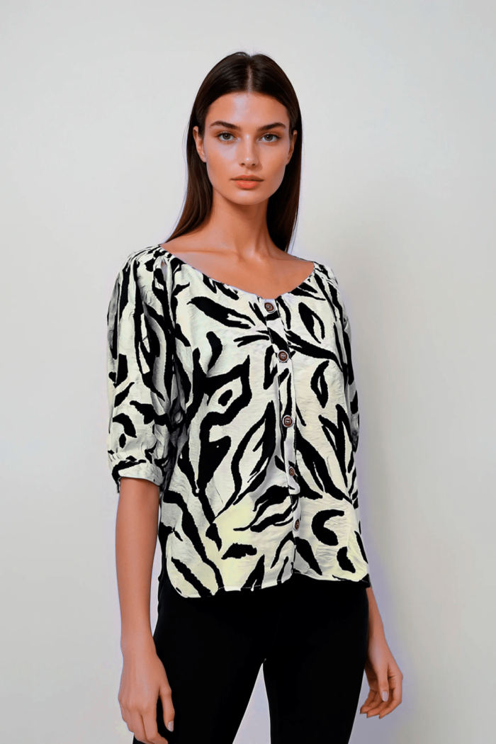 Blusa negra y crema con estampado animal print y mangas abullonadas.