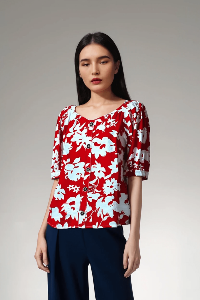 Blusa con estampado floral rojo y blanco, escote redondo y mangas abullonadas.